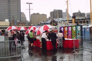 A crowd of guests under red-and-white Hong Kong umbrellas at the South Street Seaport pier during the rainy Circle Line ferry christening, September 10, 2001, photographed by Jack Hartzman.
