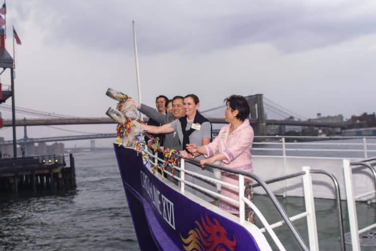 The Chancellor and his wife christen the Circle Line XVI ferry, tossing ribboned bottles over the bow with the Brooklyn Bridge behind them, September 10, 2001, photographed by Jack Hartzman.